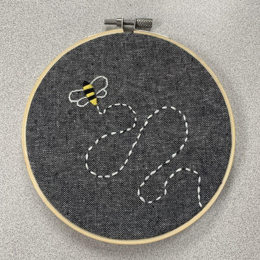 Embroidery project depicting a bee doing a waggle dance