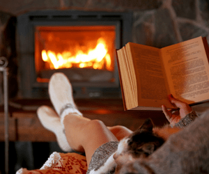 Books to Warm Your Heart. Reading a Book by a Lit Fireplace